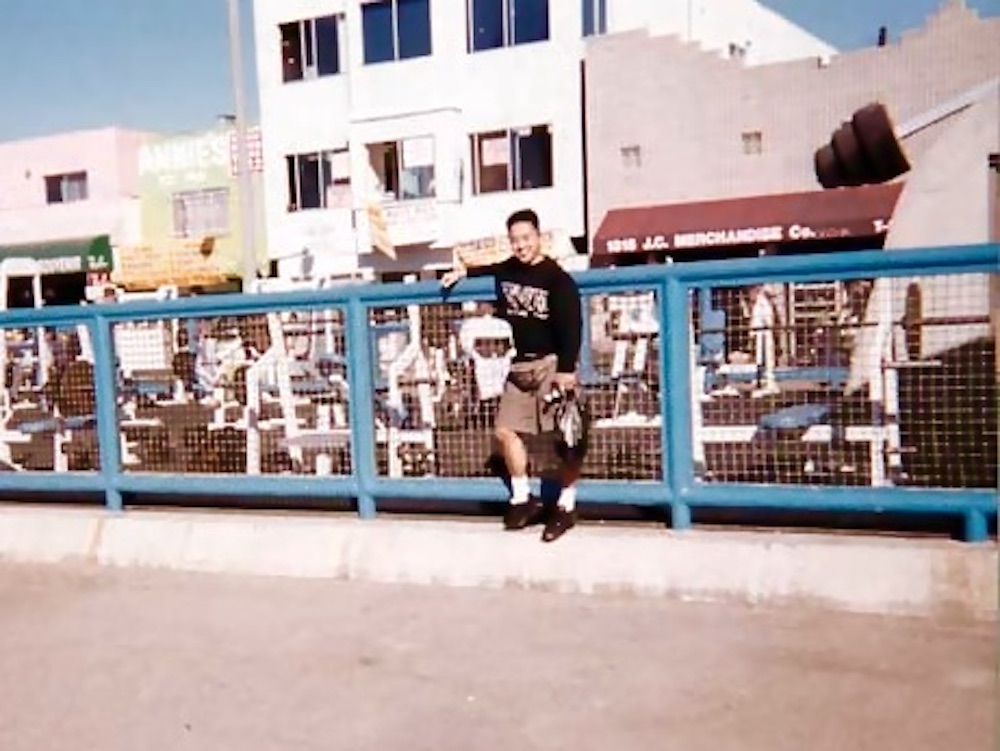 マッスルビーチジムをバックにパーソナルトレーナー小林素明が写真撮影