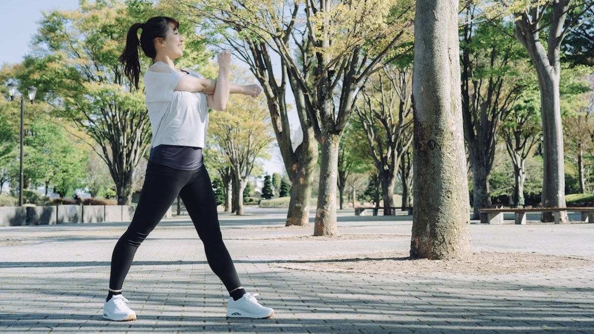 公園でストレッチエクササイズする女性