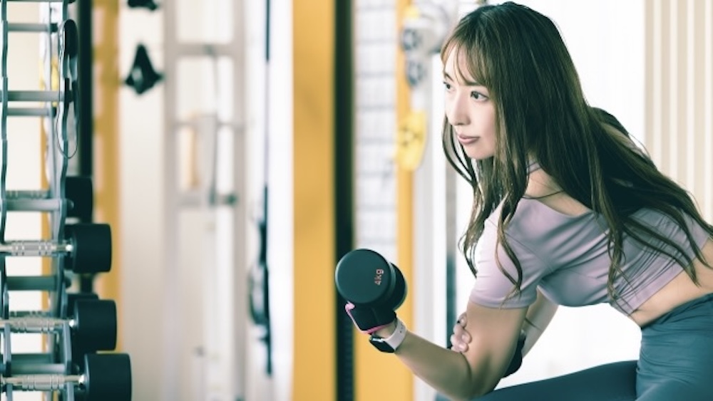 ダンベルカールをするフィットネス女性