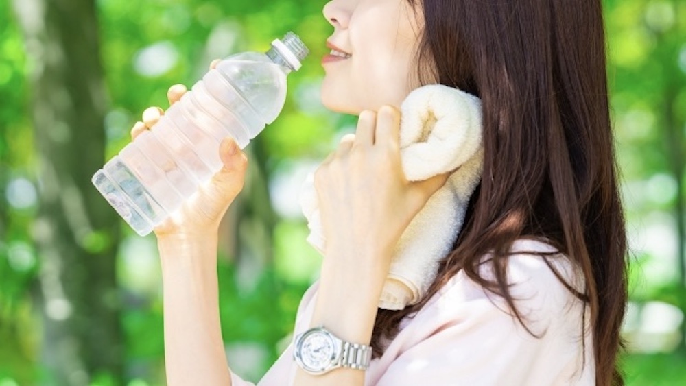 熱中症対策で水分補給する女性